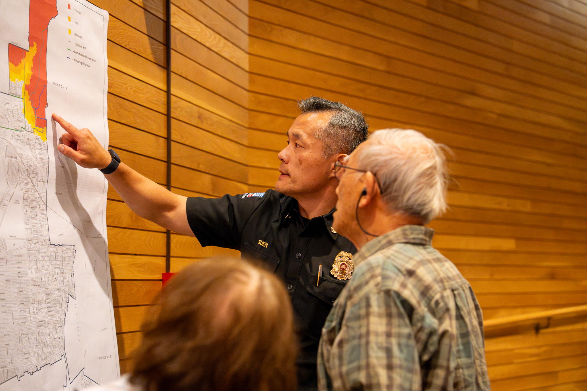 Arcadia Fire Chief Chen Suen points at a map for a community member.